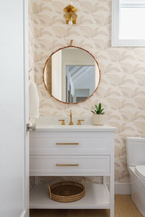 Half bathroom featuring a neutral color bird wallpaper, white cabinet with brawss hardware, round mirror Modern Powder Room Wallpaper, Coastal Half Bath, Powder Room Wallpaper Modern, Modern Powder Room, Powder Room Wallpaper, Woven Trays, Statement Wallpaper, Modern Birds, Guest Bathrooms