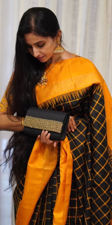 She has draped a black kanjivaram silk saree with yellow checks that showcase a bright passion flower tissue border through a gopuram (aka temple) korvai. The pallu is similar to the border with rich tissue design. Tissue Design, Kanchi Saree, Checks Saree, Kanjivaram Saree, Kanjivaram Silk Saree, Kanjivaram Sarees, Passion Flower, Parisian Chic, Yellow Black