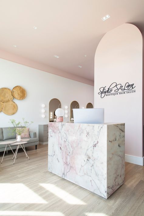 Pink-veined marble-clad reception desk. Beauty Salon Reception Ideas Spa, Reception Salon Ideas, Spa Reception Desk Design, Nail Salon Reception Desk, Spa Minimalist Design, Beauty Reception Area, Salon Reception Area Ideas, Nail Salon Reception Area, Salon Reception Ideas