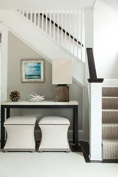 Love the table and stools... Would like this for behind a living room sofa. Console Table With Ottomans, Staircase Nook, Open Trap, Nook Decor, Under The Stairs, Nook Ideas, Gray Walls, Coastal Living Rooms, Beautiful Interior Design