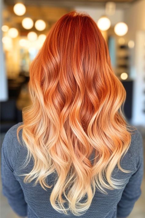 A fiery ombre transitions from vibrant red to golden blonde, reminiscent of a sunset. The long, flowing waves add a romantic and feminine touch, perfect for softening features. Click here to see more stunning red hair color ideas. Orange And Blonde Hair Color, Creamsicle Hair Color, Ginger Balayage Copper Strawberry Blonde Ombre Hair, Red Roots Blonde Ends, Vibrant Copper Red Hair, Red Hair With Blonde Ends, Fall Fantasy Hair Color, Summer Color Hair Ideas, Copper To Blonde Balayage