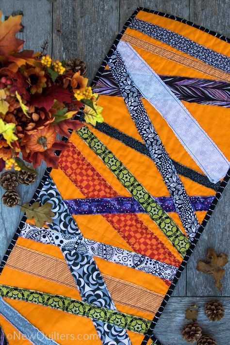 Get inspired to make a quick and easy Halloween table runner with this gallery of photos from the one we made. NewQuilters.com #halloweenquilt, #tablerunnerquilt, #tabletopperquilt Halloween Runners Table Toppers, Autumn Quilted Table Runner Patterns, Autumn Table Runners, Halloween Table Runners Patterns Free, Table Runner Quilt Patterns, Fall Table Runner Patterns, Halloween Runner, Halloween Fabric Crafts, Table Runner Quilt