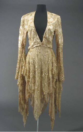 Stevie Nicks Rhiannon Costume  CIRCA 1970s  A two-piece costume worn by Stevie Nicks during a performance of the song “Rhiannon,” written by Nicks about the mythological Welsh goddess Rhiannon - the Goddess of Steeds and the Maker of Birds. The costume consists of a short champagne and gold colored jacket with lace, sequins and applied gold thread with long flowing arms, together with a matching shawl that has a zipper on the left shoulder. Stevie Nicks Prom Dress, Stevie Nicks Dress, Stevie Nicks Rhiannon, Goddess Rhiannon, Welsh Goddess, Stevie Nick, Stevie Dress, Jacket With Lace, Stevie Nicks Style