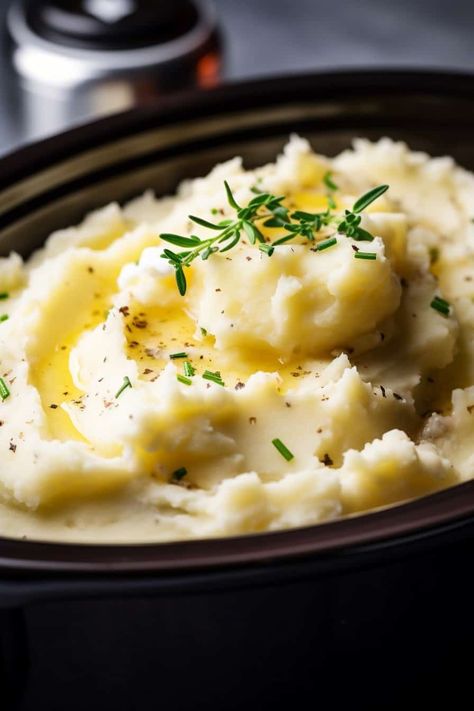 A close-up of slow cooker mashed potatoes in a crockpot, topped with a pat of butter and fresh thyme, showing a smooth and creamy texture with herbs sprinkled on top. Mashed Potatoes Food Photography, Thanksgiving Crockpot Mashed Potatoes, Thanksgiving Mashed Potatoes Recipe Crock Pot, How To Make Mashed Potatoes In Crock Pot, Crockpot Russet Mashed Potatoes, Red Mashed Potatoes Crockpot, Mashed Potatoes In A Crockpot, Crockpot Mash Potatoes, Crockpot Mashed Potatoes Recipes