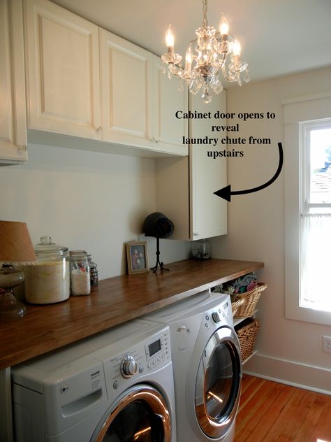 Beautiful laundry room with folding counter, hidden laundry chute, and crystal chandelier. Laundry Room Chute Ideas, Laundry Room With Chandelier, Hidden Laundry Chute, Chandelier In Laundry Room, Laundry Room Shoot Ideas, Laundry Shoot Ideas Bathroom, Hidden Laundry Shoot Ideas, Hidden Laundry Shoot, Laundry Shoot Cabinet