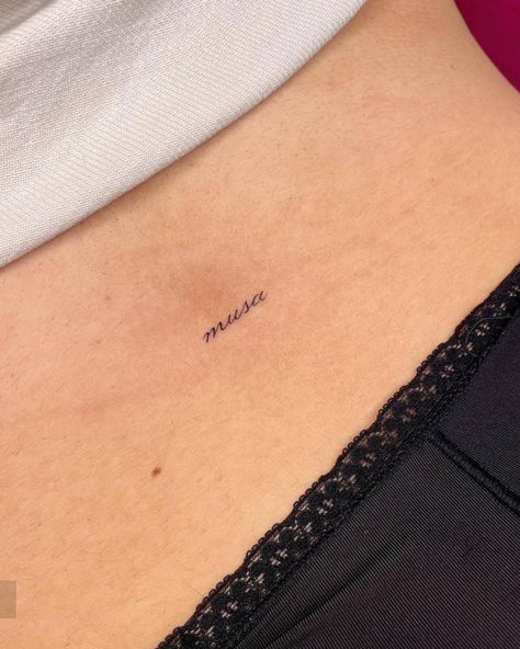 Tattoo of the word "musa" located on the lower back. Amor Tattoo Cursive, Tiny Lower Back Tattoos, Musa Tattoo, Maktub Tattoo, Lower Back Word Tattoos, Muse Tattoo Words, Lower Back Tats, Muse Tattoo, Back Tats