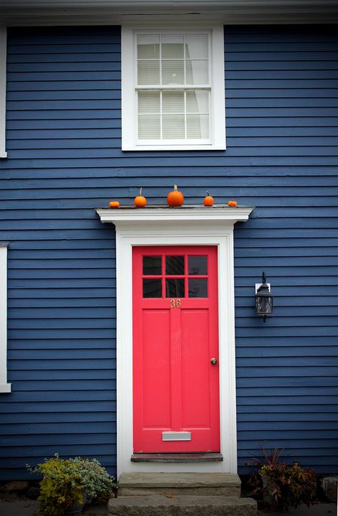 Red Door | Little orange pumpkins above the red door on blue house Navy Blue Houses, Coral Door, Red Door House, House Paint Color Combination, Exterior House Color, Dark House, Pintura Exterior, Pink Door, Exterior Paint Colors For House