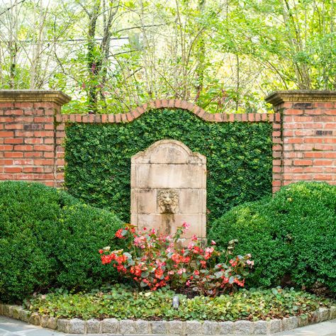 Here at Gardens to Love we take pride in making sure your garden is unique and special. This stone lion fountain among the sculpted bushes does a great job of illuminating the red brick behind it. Visit our website to learn all about the many features we could add to your space! #GardenstoLove #ATL Garden With Brick Wall, Walled In Garden, Brick Landscape Wall, Diy Brick Wall Outdoor, Brick Walled Garden, Garden Features Focal Points, Garden Feature Wall, Brick Wall Garden, Garden Brick Wall