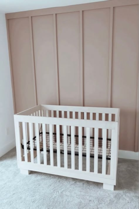 A photo of a board and batten accent wall in the color insightful rose by sherwin Williams as an accent wall in a nursery room for a baby girl Light Pink Nursery Accent Wall, Neutral Nursery With White Crib, Vertical Wood Accent Wall Nursery, Mauve Pink Accent Wall, Nursery Accent Wall Color, Cabbage Rose Sherwin Williams Nursery, Mauve Shiplap Wall, Pink Mauve Nursery, Rose Colored Nursery