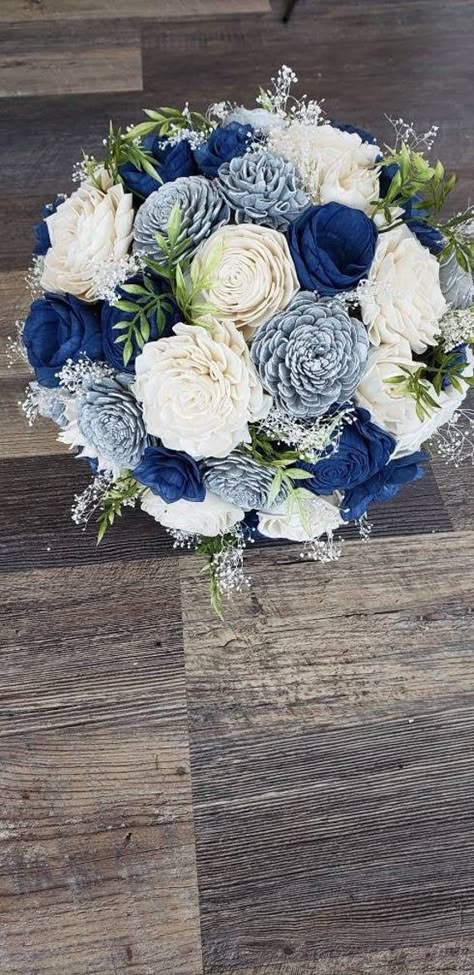 This beautiful wooden bouquet features silver and dark blue flowers with babies breath and faux greenery - a perfect mix! Pictured bouquet is 10 inches in diameter. Standard handle wrap is #1. Royal Blue And Silver Flower Bouquet, Dark Blue And White Flowers, Dark Blue Groomsmen, Dark Blue Bouquet, Wooden Bouquet, Blue Silver Weddings, Blue Flower Arrangements, Dark Blue Wedding, Blue Flowers Bouquet