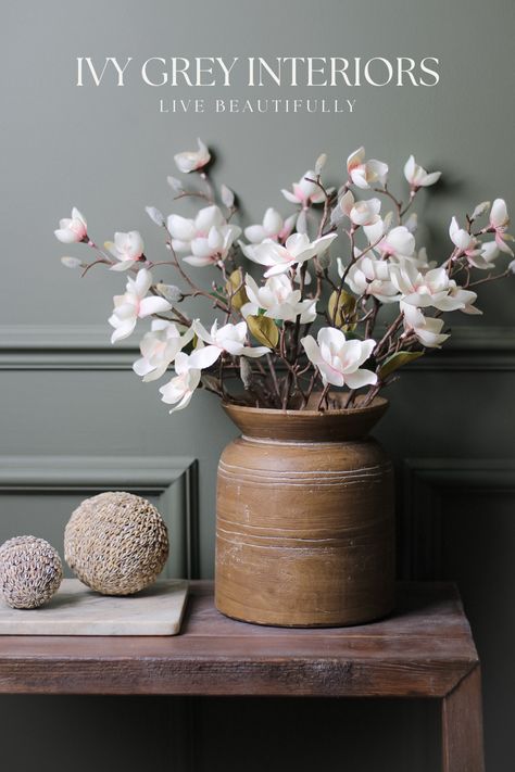 Discover the allure of nature without the upkeep! Our wood-effect cement vase, adorned with delicate faux soft pink magnolia stems, brings charm and sophistication to your home decor. Embrace the beauty of everlasting blooms with this stunning arrangement. Perfect for adding a touch of serenity to any space. Elevate your interior design game today! #HomeDecor #FauxFlowers #Magnolia #InteriorStyling #WoodEffectVase Cement Vase, Grey Interiors, Rattan Baskets, Pink Magnolia, Interior Design Games, Floral Home Decor, Live Beautifully, New Ceramics, Refresh Your Home