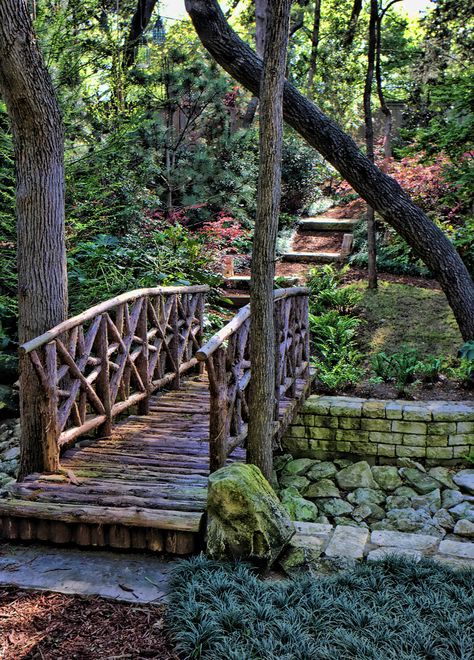 Natural branch bridge spans dry creek - Harold Leidner Co., Dallas, Texas Rustic Bridge Over Creek, Dry Creek Bed With Bridge, Fence Over Creek, Log Bridge Over Creek, Walking Bridge Over Creek, Creek Bridge Ideas, Creek Landscaping Natural, Rustic Outdoor Structures, Garden Bridge Ideas