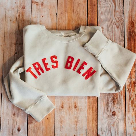 An ultimate staple in any wardrobe - a classic sweatshirt. The Magill Vintage Ivory Crewneck Sweatshirt is crafted from a cotton/polyester blend making it soft and with a semi-structured silhouette. "TRES BIEN" means "VERY GOOD" in French, something we know you'll feel when wearing this sweatshirt. Looking to customize Vintage Sweatshirt Outfit, Custom Sweatshirt Ideas, Classic Sweatshirt, Closet Fashion, Vintage Sweatshirt, Everyday Fashion, Crewneck Sweatshirt, What To Wear, Fall Outfits