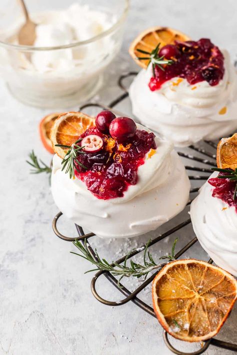 Mini Cranberry Pavlovas combine the crisp outer layer with a soft chewy centre. The meringue is topped with a lightly whipped cream and orange infused cranberry sauce, Light, delicate, crisp, soft, sweet and tangy encapsulate this festive, holiday dessert. By Emma Duckworth Bakes. Cranberry Meringue, Meringue Nests, Mini Pavlovas, Mini Meringues, Baked Meringue, Cranberry Orange Sauce, Mini Pavlova, Cranberry Cream Cheese, Pavlova Recipe