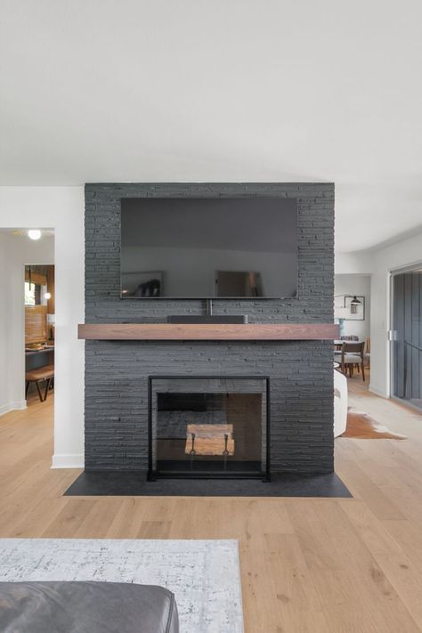 This existing fireplace was updated with a fresh coat of Sherwin-Williams Iron Ore (SW 7069). Iron Ore Painted Brick Fireplace, Iron Ore Mantle, Urban Bronze Fireplace Wall, Iron Ore Sherwin Williams Fireplace, Iron Ore Fireplace, Iron Ore Sherwin Williams, Whole House Remodel, Painted Brick Fireplace, Paint Fireplace