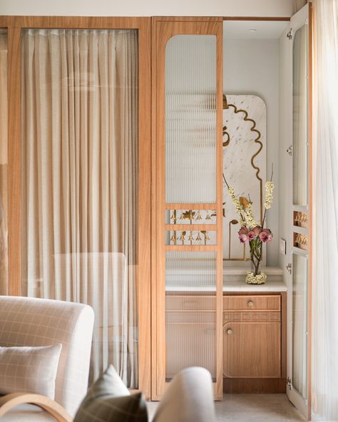 The mandir space of the Kābu home ❤️ When we brought down a bedroom wall to allow for more light in the living-dining spaces, we created a small space for the mandir. Minimal just like the rest of the home but warm and elegant , we conceptualised a marble back panel here with brass inlaid lotuses and religious motifs. A fluted glass door with strings of bells in a cutout in the middle, adds to the pious charm 🥰 . Photo credit: @nayansoni21 . . #studioipsa mandir | puja room | interior... Mandir Design Door, Studio Home Ideas, Puja Room Interior Design, Small Puja Room Ideas, Small Pooja Room In Living Room, Temple In Home, Small Mandir Design, Mandir Ideas For Small Space, Pooja Corner