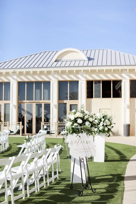 Waterfront Lawn Timeless Elegant Wedding Ceremony Decor, White Folding Chairs, Acrylic White and Gold Welcome Sign with White Roses, Greenery Floral Arrangement | Tampa Bay Wedding Photographer Lifelong Photography Studio | Clearwater Beach Wedding Venue Sandpearl Resort | Wedding Planner Blue Skies Weddings and Events | Wedding Florist Iza's Flowers White Rose Isle Wedding, Elegant Wedding Ceremony Decor, Outdoor Wedding Ceremony White Chairs, White Roses Down Isle, Lawn Wedding Ceremony, White Rose Lined Aisle, Newport Beach Country Club Wedding, Gold Welcome Sign, Greenery Floral Arrangement