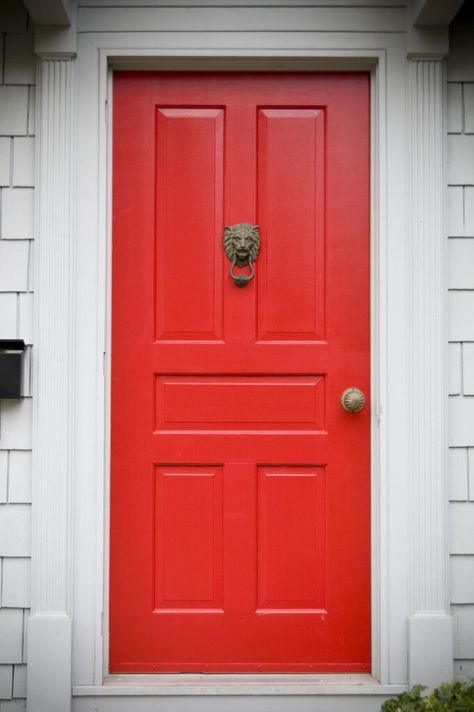 Off-white molding and framing support this bright red door, which has five rectangular panels and features a bronze doorknocker and a bronze doorknob. A black mailbox fixed to the wall is placed at the left side of the door. Red Door House, Vinyl Door, Red Doors, House Porch, Red Front Door, Exterior Stairs, Door Paint Colors, Front Door Porch, Exterior Wall Design