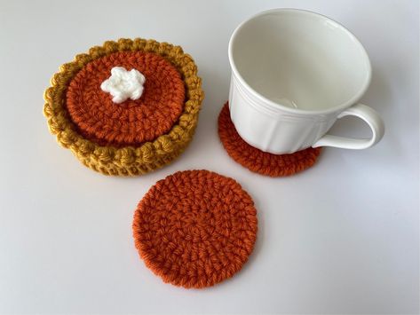 "More \"flavors\" coming soon! One of many MOD&MINIcrochet shop collectibles! This mini pumpkin pie coaster set of 5 is both delightful and functional! The bottom tart shell also acts as a coaster and holds 4 \"filling\" coasters. The top coaster has a dollop of whipped cream. The top coaster has an optional dollop of whipped cream due to whipped cream topping can make the top coaster slightly unstable when used.  When they're not in use, stack them in the tart shell and you have an adorable decoration. Perfect for home and work decor as well as birthday and holiday gifts! Size: Total height is approximately 2 inches tall. Total diameter of tart shell is approximately 4.5 inches. Diameter of \"filling\" coasters is approximately 3.5 inches. Note: These are lovingly handmade - details, colo Pumpkin Pie Crochet, Crochet Fall Coasters, Crochet Pumpkin Pie, Pie Crochet, Crochet Coaster Set, Quick Crochet Projects, Crochet Coaster, Mini Crochet, Crochet Business