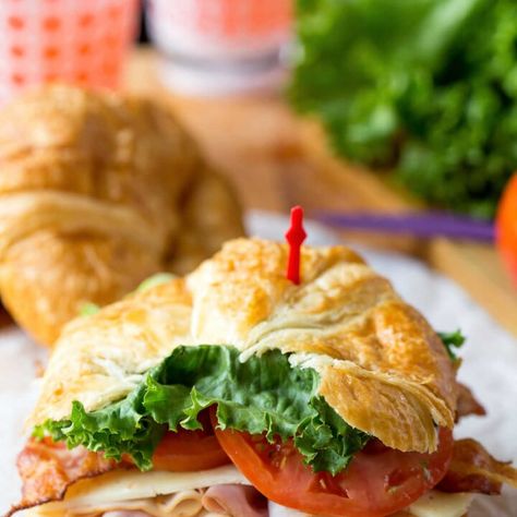 California club croissant sandwich on a piece of white parchment paper. Club Croissant Sandwich, Sliders Sandwiches, Baked Ham And Cheese Sliders, Ham And Cheese Sliders, Slider Sandwiches, Croissant Sandwich, Cheese Sliders, Weeknight Dinner Recipes Easy, Leftover Ham