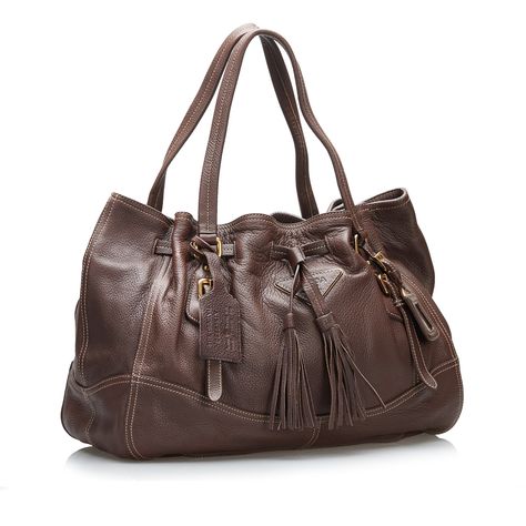 Product Details: Brown Prada Cervo Drawstring Leather Tote. This tote bag features a leather body, flat straps, an open top with magnetic with a tassel drawstring closure, and an interior zip pocket. 11.8" L x 16.1" W x 6.1" D, 6.3" drop. Condition: . Good. Exterior Front Discolored, Out Of Shape, . Exterior Back Out Of Shape, . Exterior Bottom Out Of Shape, . Exterior Bottom with Other. Exterior Handle Out Of Shape, . Exterior Corners . Exterior Side Out Of Shape, . Exterior Top Out Of Shape, . Interior Lining with Other. Practical Attachment Scratched. Zipper Scratched. Please note this is a item that may display signs of wear consistent with the condition listed above and shown in photos. Designer Revival this is an Brown Prada Cervo Drawstring Leather Tote or . Learn more about our ati Miuccia Prada, Vuitton Bag, Diaper Backpack, Open Top, Casual Backpack, Fashion Labels, Italian Fashion, Tote Handbags, Leather Tote