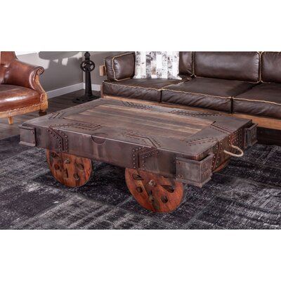 The Colindas collection combines vintage, rustic, and modern elements to create truly inspiring pieces crafted of reclaimed materials and metals in natural finishes. Each piece of furniture in this unique collection features fun, vintage details blended with functionality like adjustable cranks to fuse modern elements into the rustic styling. This hand-crafted coffee table's legs are wheels of reclaimed need wood, which are operable affording easy of transportability. The coffee table top featur Steampunk Coffee Table, Industrial Cart, Modern Industrial Furniture, Table Wood Metal, Live Edge Furniture, Vintage Industrial Furniture, Coffee Table Legs, Vintage Details, Industrial Coffee Table