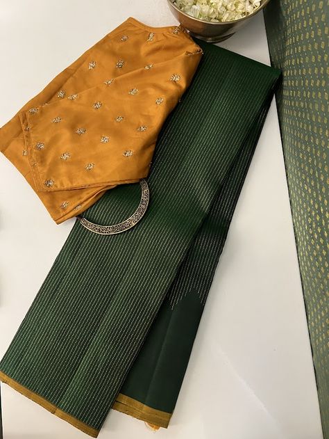 A gorgeous green monotoned pure handwoven kanchipuram silk saree with a beautiful mustard selvedge and blouse may seem simple at first glance but the magic is all packed into the pure zari work thats so intricately and thoughtfully done on it. Delicate pure zari threads gradually ascend along the border, reaching their peak at the pallu. In an unexpected twist, the pallu is with traditional muthu lines , adding a unique touch to its elegance. Mysore Silk Saree Styling, Green Mysore Silk Saree, Modest Blouse, Simple Saree Designs, Mysore Silk Saree, New Saree Designs, Silk Saree Kanchipuram, Traditional Blouse Designs, Cotton Saree Designs