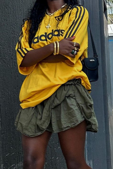 Effortlessly sporty and chic: pair your favorite Adidas yellow jersey with a vibrant green skirt for a casual yet stylish look. Complete the outfit with gold jewelry to elevate your sporty style. Perfect for any occasion! 🌟 #JerseyAndSkirtOutfit #SportyFashion #CasualChic #AdidasFashion #StreetStyle #WomensFashion #jerseyoutfitblackwomen Yellow Adidas, Trendy Bottoms, Look Festival, Jersey Outfit, Looks Black, Sporty Outfits, Sporty Chic, May 22, Girly Outfits