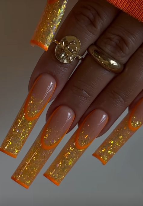 Orang And Gold Nails, Orange And Glitter Acrylic Nails, Orange Winter Nails, Orange And Gold Nails Acrylic, Long Acrylic Nails Orange, Metallic Orange Nails, Orange Glitter Nails Acrylic, Orange Nails With Rhinestones, Orange Christmas Nails