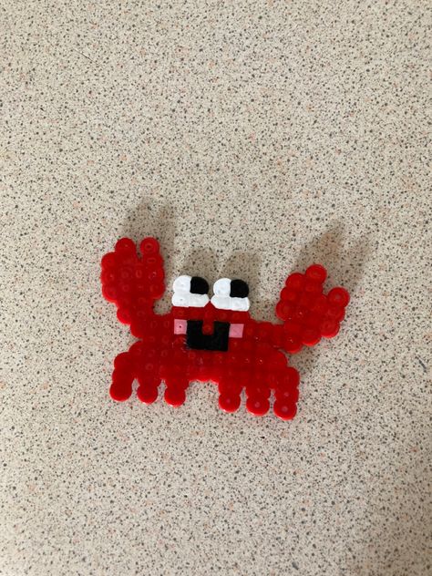 A red crab with pink cheeks, made out of hamma beads Pearl Or Bead Ideas Cute, Small Shark Perler Beads, Crab Perler Beads, Iron On Beads Ideas, Betta Fish Perler Beads, Ironing Beads Ideas, Crab Pixel Art, 3d Perler Bead Fish, Red Crab