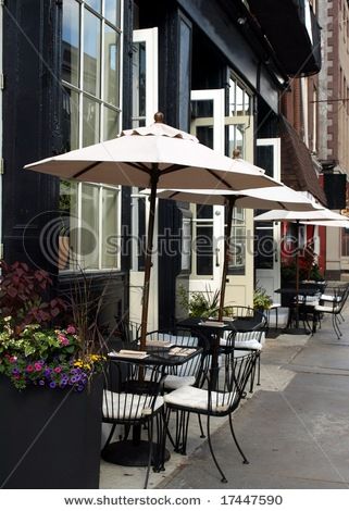 Doors open out from the indoor restaurant to an outdoor cafe with tables under umbrellas. Table Umbrella Decorations, Lotus Sunscreen, Outdoor Cafe Seating, Cafe Umbrella, Outdoor Seating Cafe, Outside Cafe, Outdoor Restaurant Patio, Floor Seating Living Room, Umbrella Table