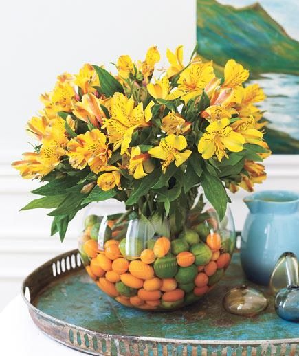 This tone-on-tone assemblage starts with miniature citrus fruits (key limes, kumquats) and Peruvian lilies bursting with color. Fishbowl Centerpiece, Refreshments Table, Glass Fish Bowl, Fruit Centerpieces, Peruvian Lilies, Festa Harry Potter, Spring Centerpiece, Simple Centerpieces, Beautiful Centerpieces