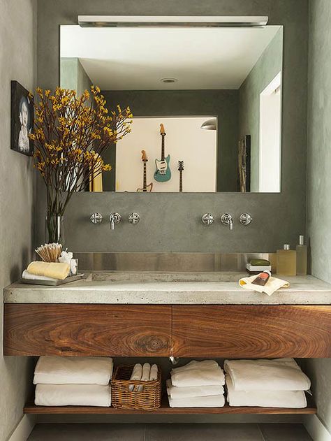 A concrete countertop and stainless-steel backsplash provide a contemporary feel to this small space. Concrete Bathroom Design, Bilik Air, Concrete Bathroom, Bathroom Design Inspiration, Trendy Bathroom, Bath Room, Modern Bathroom Vanity, Bathroom Renos, House Bathroom