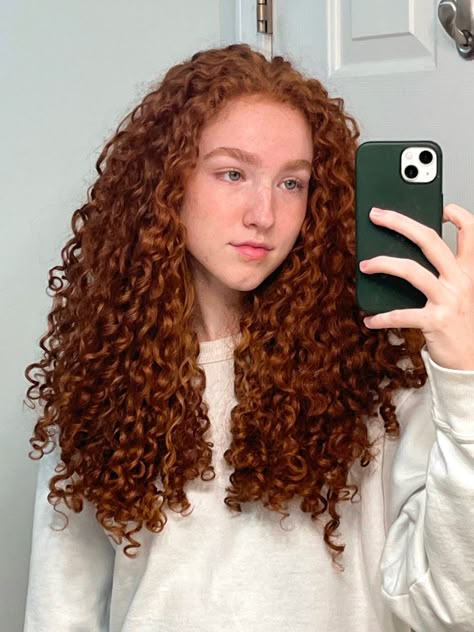 A girl with big curly red hair is taking a mirror selfie. The girl has green eyes and freckles. She is wearing a white crew neck. The countertop and walls are white. Her phone case is a deep forest green. Ginger Hair Color Curly, Red Curly Hair Natural, Dark Ginger Curly Hair, Ginger Hair Curly, Reddish Brown Curly Hair, Ginger Curly Hair, Curly Ginger Hair, Curly Color, Red Curls