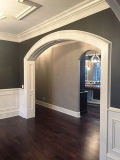 Custom trimmed cased arches with paneled jambs and paneled arched top. Adding Arches To House, Arched Cased Opening, Timeless Dining Room, Transitional Dining Room, Room Extensions, Wood Dining Room, Door Trims, Wood Trim, Black Walls