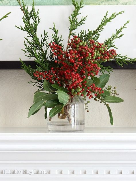 Simple ideas for Christmas mantels with fresh greenery. #decoratingmantels #christmasdecor #christmasmantel #mantelswithgarland #pepperberryarrangements Holly Centerpiece Christmas, Simple Christmas Arrangements, Christmas Bouquet Centerpiece, Boho Christmas Floral Arrangements, Simple Christmas Flower Arrangements, Simple Christmas Floral Arrangements, December Arrangements, Easy Christmas Floral Arrangements, Christmas Vase Centerpiece Ideas