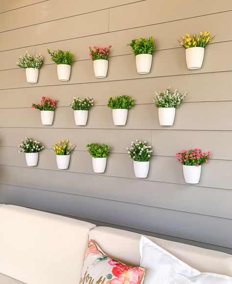 DIY plant wall decor for patio, outdoor design, faux flowers in hanging white pots, easy project for outdoor design Plant Wall Patio, Diy Plant Wall, Patio Wall Decor, Porch Wall Decor, Beautiful Wall Hanging, Plant Wall Decor, Vertical Planter, Backyard Flowers, Patio Wall