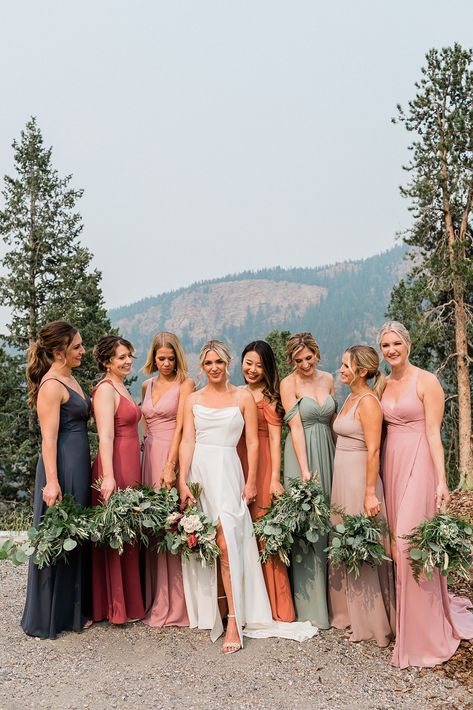 Seven bridesmaids in multicolored dresses stand around a bride in a modern dress against a mountain background. Eucalyptus Bouquets, August Wedding Colors, Mismatched Bridesmaids Dresses, Fall Mountain Wedding, Mix Match Bridesmaids, Fall Wedding Color Palette, Wedding Parties Colors, Fall Bridesmaids, Events Planning