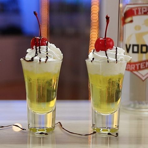 BANANA SPLIT SHOT 3/4 oz. (22ml) Vodka 3/4 oz. (22ml) Creme De Banana 1/4 oz. (7.5ml) Vanilla Syrup Garnish: Whipped Cream, Chocolate Syrup, Maraschino Cherry PREPARATION 1. In an ice filled glass combine vodka, creme de banana and vanilla syrup. Shake well. 2. Strain mix into shot glasses and top with whipped cream. 3. Drizzle chocolate syrup on top and garnish with a Cherry. DRINK RESPONSIBLY! Fruity Shots, Shots Alcohol Recipes, Whipped Cream Chocolate, Shooter Recipes, Bartender Drinks, Cocktail Drinks Alcoholic, Shots Alcohol, Tipsy Bartender, Mixed Drinks Alcohol