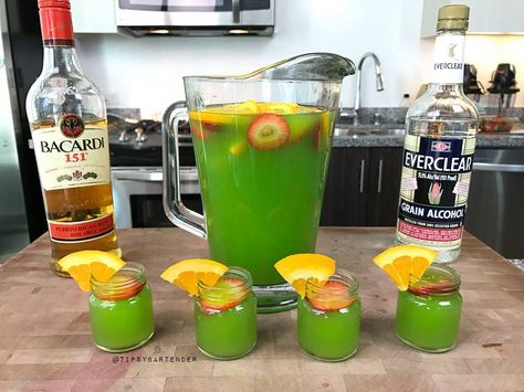 Green Jungle Juice - For more delicious recipes and drinks, visit us here: www.TopShelfPours.com Green Jungle Juice, Green Jungle Juice Recipe, Tipsy Bartender Jungle Juice, Alcoholic Jungle Juice, Green Alcoholic Drinks, Jungle Juice Recipe, Bacardi 151, Juice Shots, Halloween Juice