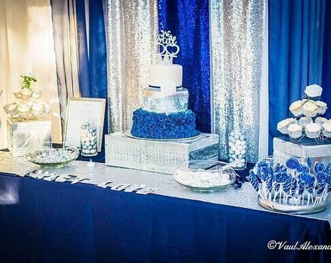 Impart grandeur to your dessert table by using silver & royal blue décor elements. Make a shiny backdrop with silver & royal blue sequin curtains and adorn the table with a royal blue tablecloth spreading a silver sequin runner on top. Fill your candies in glass bowls and cylindrical vases and paint a Styrofoam ring silver to create stylishly arrange candy sticks. Also, place silver display boxes embellished with silver rhinestones and perch cake & cupcake stands on them to ooze glamour. Shiny Backdrop, Event Decor Ideas, Sequin Curtains, Party Decorations Table, Silver Display, Cake And Cupcake Stand, Blue Tablecloth, Cupcake Stands, Candy Sticks