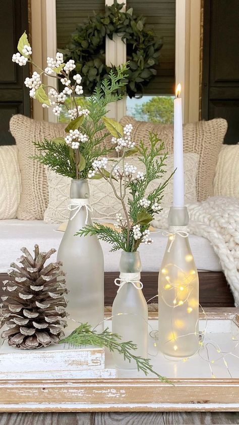 DIY frosted glass bottles with winter greens, white berries, taper candles, and fairy lights in them. Christmas Glass Bottles Diy Projects, Wine Bottle Diy Decor, Frosted Wine Bottle Centerpieces For Wedding, Glass Bottle Ideas Decoration, Recycling Glass Bottles, Glass Bottle Upcycle, Upcycling Glass Bottles, What To Do With Glass Bottles, Glass Bottle Crafts Home Decor