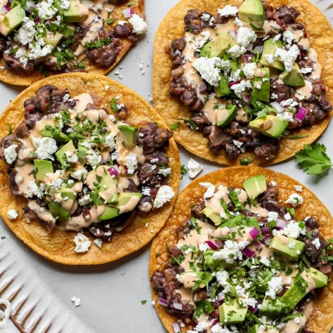 Black Bean Tostadas with Jalapeño-Feta Sauce Vegetarian Tostadas, Black Bean Tostadas, Bean Tostadas, Traditional Refried Beans, Feta Sauce, Vegetarian Tacos Recipes, Mexican Dinners, Dishing Out Health, Mexican Favorites