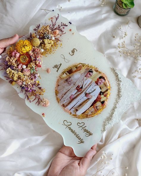 Preserve the magic of your special day with this handcrafted resin anniversary frame! 💕✨ Featuring preserved florals, shimmering details, and your cherished memory at its heart, this keepsake is perfect for celebrating love that grows with each passing year. 🌸✨ Thoughtful, timeless, and oh-so-beautiful! 9x12 inch Resin Frame with dried botanicals and the couple's photo. Paired with a gold stand for support 💌 DM us or click the link in bio to create a frame that tells your story forever! -... Resin Photo Frame For Anniversary, Resin Frames For Couples, Resin Memorial Ideas With Flowers, Resin Photo Frame, Resin Photo, Dried Botanicals, Anniversary Frame, Resin Crafts Tutorial, Resin Frame