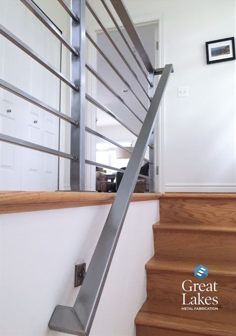 A stainless steel horizontal stair rail that accents a contemporary home. Oak hardwood flooring adds to the clean and classic feel. Horizontal steel bars frame the stairs and a brushed stainless steel handrail anchors the steps. Save and share today! Stairs Handle, Outdoor Railings, Stainless Steel Stair Railing, Staircase Manufacturers, Hand Railing, Metal Stair Railing, Steel Railing Design, Stair Rails, Patio Railing