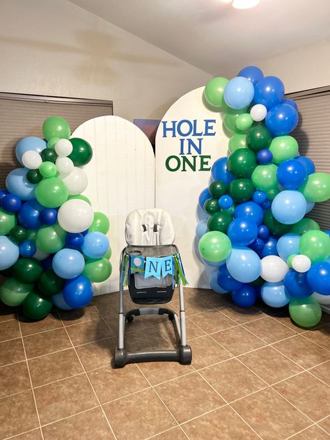 Blue, green, white, backdrop, balloon arch, high chair, one, hole in one, first birthday Hole In One First Birthday Balloon Arch, Hole In One Balloon Arch, Hole In One Backdrop, Hole In One First Birthday Backdrop, Golf Balloon Arch, Golf First Birthday Party, Hole In One First Birthday, Balloon Arch Backdrop, High Chair Decorations