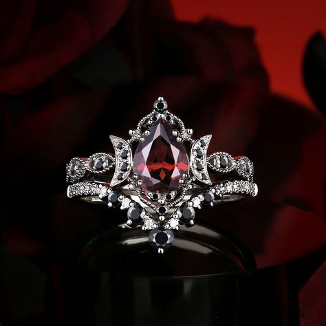 The striking contrast of red and black in ring design evokes an intense, dramatic elegance, merging passion and mystery into a bold statement of timeless beauty. Follow @starlandusjewelry for more nontraditional jewelry/alternative engagement rings! #ringselfie #ringlover #engagementring #jewelrybrand #jewelry #moissanitering #weddinginspo #diamond #moissaniteweddingring #jewelrydesigner #engagementringsforwomen #nontraditional #alternativebride #garnet #garnetring #garnetjewelry #foryoupag... Red Diamond Wedding Ring, Dark Fantasy Engagement Ring, Vintage Gothic Wedding Rings, Black And Red Wedding Ring, Gothic Rings Engagement, Witchy Wedding Rings, Goth Engagement Rings, Jewelry Alternative, Gothic Wedding Rings