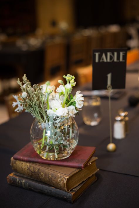 Centerpiece With Books And Flowers, Academic Centerpieces, Old Book Centerpieces, Old Books Wedding Decor, Antique Book Centerpieces, Nerdy Centerpieces, Book Centerpiece Wedding, Centerpieces With Books, Centerpiece With Books