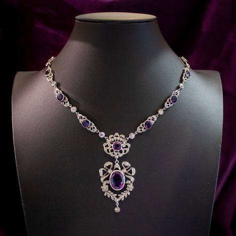 New in! A magnificent antique Edwardian paste lavaliere necklace consisting of ornate silver links leading to a spectacular open-work dropper pendant featuring pretty bow and floral motifs. Each link is bezel set with a large purple paste and accompanied by smaller clear pastes that together simulate amethysts and diamonds. The antique necklace dates to the early 1900s and has remained in excellent condition. It’s held by a safety chain and a flower-shaped box clasp at the end topped with f... Antique Necklace Victorian, Paste Jewelry, Flint Glass, Edwardian Engagement Ring, Dr Closet, Princess Jewelry, Edwardian Jewelry, Oc Inspo, Purple Necklace