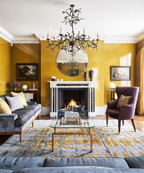 a quirky modern living room with mustard walls, a fireplace, a beautiful statement chandelier and elegant furniture Mustard Living Rooms, Yellow Walls Living Room, Yellow Decor Living Room, Mustard Yellow Walls, Mustard Walls, Victorian Living Room, Yellow Room, Yellow Living Room, Living Room Color Schemes